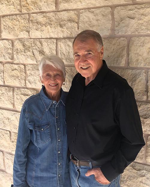 Phil and Betty Roether, standing against a brick wall