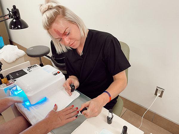 Cosmetology student performing manicure